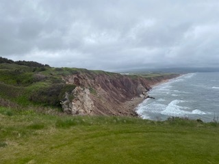 Red cliffs and beach beside the fairway on the Nova Scotia coast